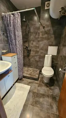 a bathroom with a toilet and a shower at Уютно студио до центъра на Бургас in Burgas City