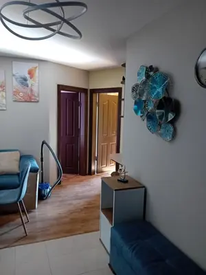 a living room with a blue couch and a mirror at Тристаен апартамент Еуфория, Свети Влас in Sveti Vlas