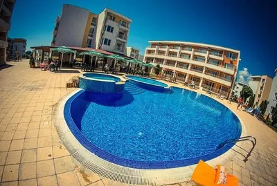 a large blue swimming pool in front of a building at Ground Floor, 2-Bed Apartment in Sunny Beach