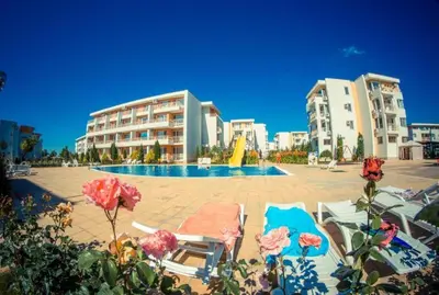 a resort with a pool and some chairs and buildings at Ground Floor, 2-Bed Apartment in Sunny Beach