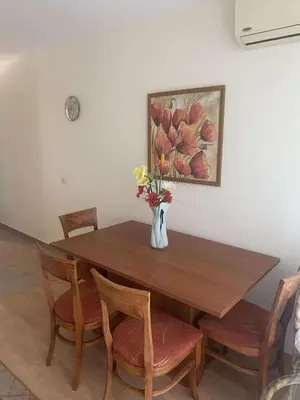 a dining room table with a vase of flowers on it at Ground Floor, 2-Bed Apartment in Sunny Beach