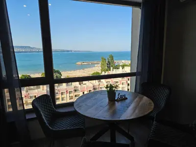 a table in front of a window with a view of the ocean at Comfy Flat Sea View & Strong Wi-Fi in Varna City