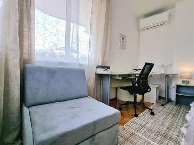 a living room with a chair and a desk with a computer at Central - 3BD Holiday Apartment for Family & Friends in Burgas City