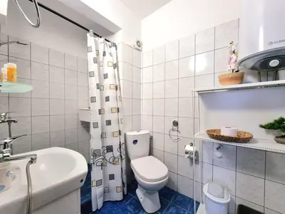 a white bathroom with a toilet and a sink at Central - 3BD Holiday Apartment for Family & Friends in Burgas City