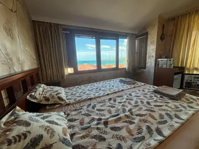 a bedroom with two beds and a large window at Стая за гости - 1 in Sozopol