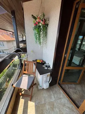 a balcony with a table and a chair and a plant at Стая за гости - 1 in Sozopol