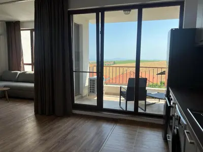 a living room with a large sliding glass door with a balcony at Deluxe Apartment with Sea View Vineyard Spa Resort Aheloy in Aheloy