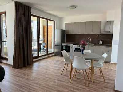 a kitchen and dining room with a table and chairs at Deluxe Apartment with Sea View Vineyard Spa Resort Aheloy in Aheloy