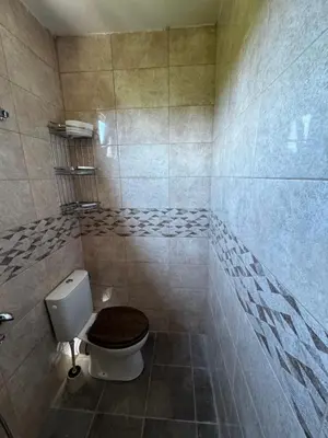 a bathroom with a toilet with a wooden seat at Вила Бонита плаж Градина in Burgas City