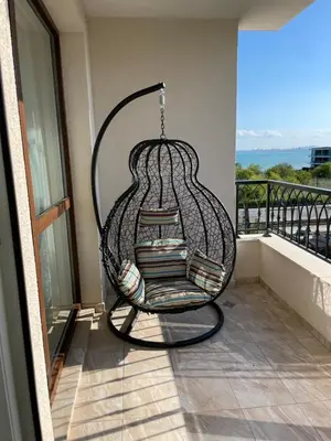 a hanging chair with books on a balcony at Сарафово in Burgas City