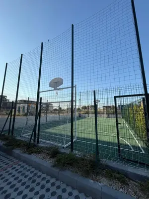 a fence with a basketball hoop in a field at Сарафово in Burgas City