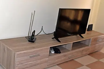 a flat screen tv sitting on top of a wooden entertainment center at Anvers Apartments in Sozopol