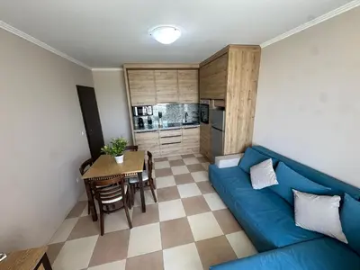 a living room with a blue couch and a table at Anvers Apartments in Sozopol