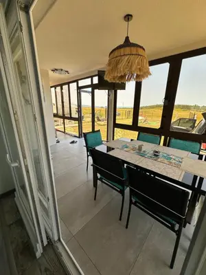 a dining room with a table and chairs and a window at Морски Бриз in Lozenets