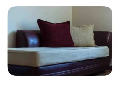 a brown leather couch with two pillows on it at Guesthouse Christina in Varna City