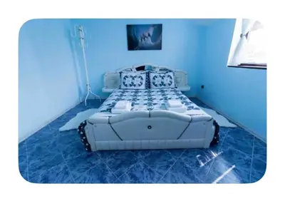a large white bed in a blue room at Guesthouse Christina in Varna City