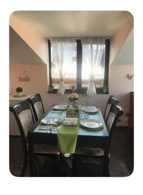 a dining room table with a green tablecloth and chairs at Guesthouse Christina in Varna City