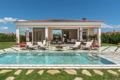 a house with a swimming pool with chairs and a patio at Villa Dolce Vita in Sunny Beach