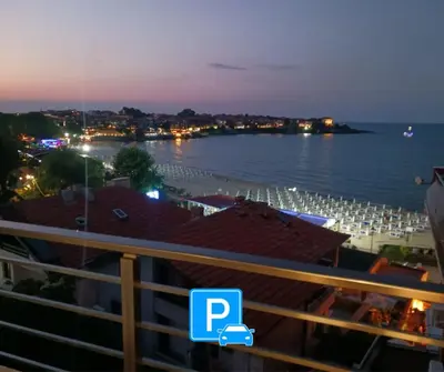 a view of the beach at night from a balcony at Sineva apartment - perfect location and amazing view in Sozopol
