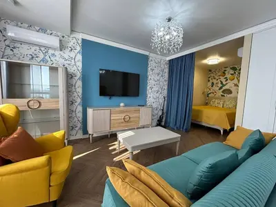 a living room with a couch and a tv at Bayview Family 2 in Burgas City