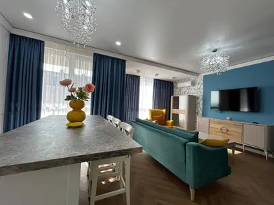a living room with a table and a blue couch at Bayview Family 2 in Burgas City