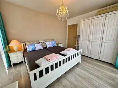 a bedroom with a large bed with a chandelier at Apartment B48 in Tarsis Club Complex in Sunny Beach