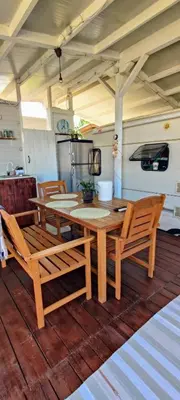 a wooden table and chairs on a wooden deck at Яката Каравана in Kiten