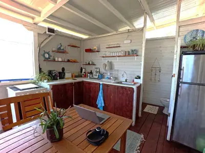 a kitchen with a table and a laptop on a table at Яката Каравана in Kiten