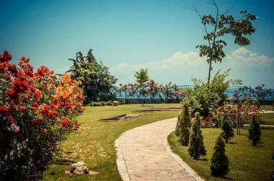 a park with a pathway and flowers and a roller coaster at Beachfront Studio with Sea Views in Sveti Vlas