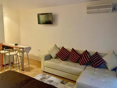 a living room with a couch with pillows on it at Beachfront Studio with Sea Views in Sveti Vlas