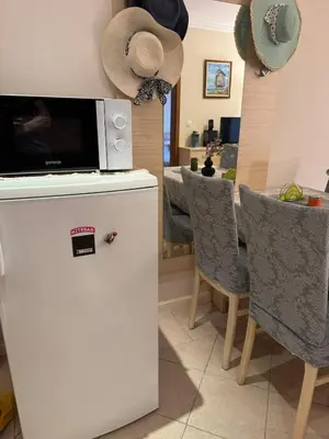 a kitchen with a microwave on top of a refrigerator at Apartment at the Seaside in Sozopol