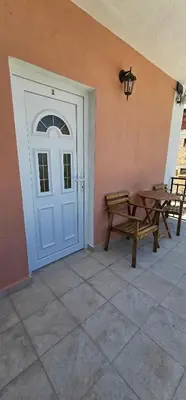 a door to a house with a table and a bench at Victoria guest house in Obzor