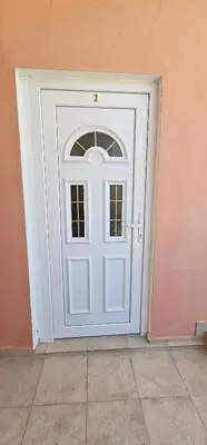 a white door in a pink wall at Victoria guest house in Obzor