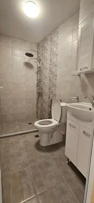 a bathroom with a toilet and a shower and a sink at Victoria guest house in Obzor