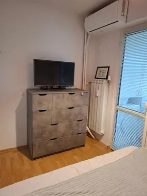 a bedroom with a dresser with a flat screen tv on it at Accommodation apartment MARGARITA in Burgas City
