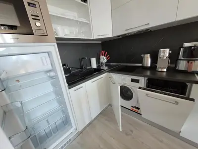 a kitchen with white cabinets and an open refrigerator at Millenium II B34 in Sveti Vlas