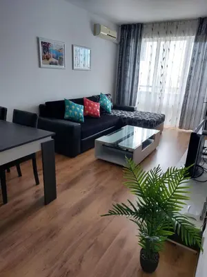 a living room with a black couch and a table at Royal Palm 170 in Sveti Vlas