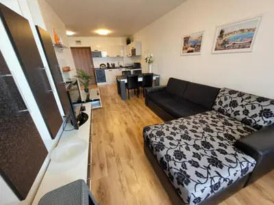a living room with a couch and a kitchen at Royal Palm 170 in Sveti Vlas