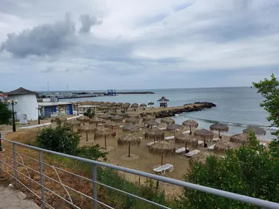 a beach with many straw umbrellas and the ocean at Royal Palm 170 in Sveti Vlas