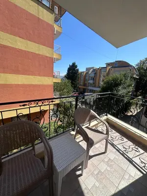 two chairs on a balcony with a train in the background at Villa Tanita in Ravda