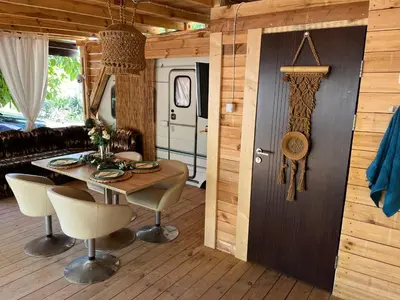 a dining room with a table and chairs in a cabin at Каравана Бамбоо in Sozopol