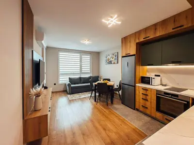 a kitchen and living room with a table and a couch at Sea Horizon in Burgas City