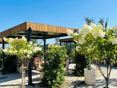 a pavilion with white flowers and trees in a park at Sea Horizon in Burgas City