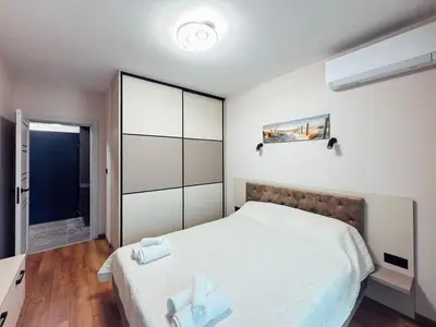 a bedroom with a large white bed and a window at Sea Horizon in Burgas City