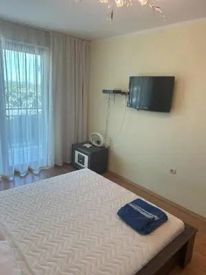 a bedroom with a bed and a tv on the wall at Appart complex - Egrek 6 in Lozenets