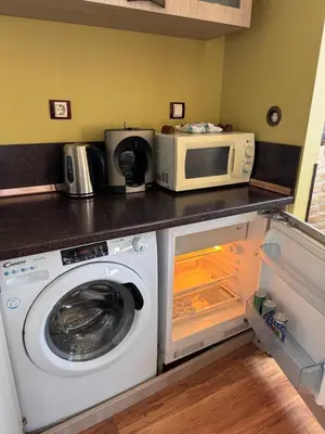 a kitchen with a washing machine and a microwave at Sea View Escape in Burgas City