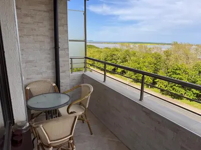 a balcony with a table and chairs and a view of the water at Sea View Escape in Burgas City