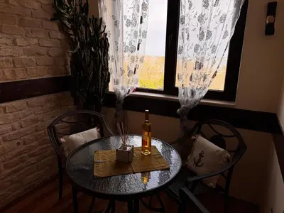 a table with a bottle of wine on it in front of a window at Sea View Escape in Burgas City