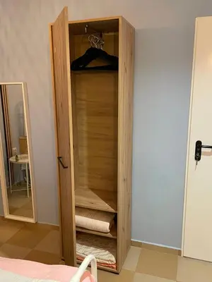 a wooden closet with towels in a room at Blue Home in Burgas City
