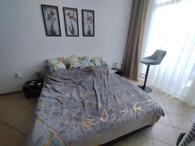 a bedroom with a bed and a chair in it at Grand Kamelia C1 in Sunny Beach